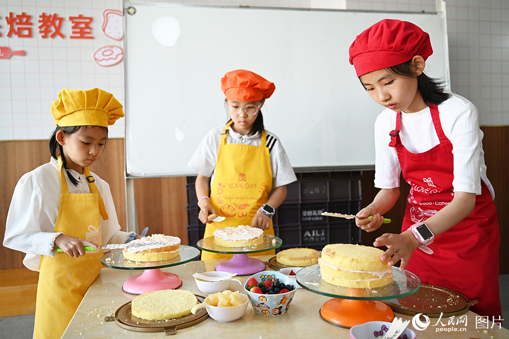2026年5月30日，在甘肅蘭州一家蛋糕店內(nèi)，孩子們體驗蛋糕烘焙。人民網(wǎng) 席娟娟攝