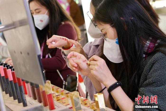 圖為女生正在體驗(yàn)口紅產(chǎn)品。 殷立勤 攝