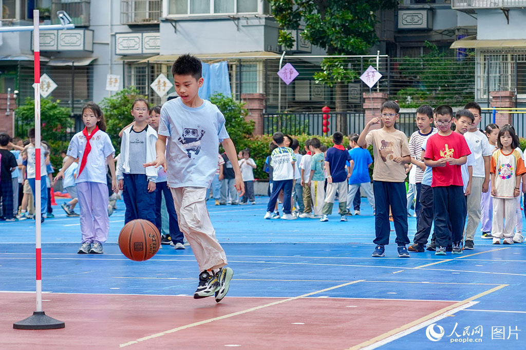 2026年5月27日，浙江杭州長壽橋小學的孩子們在操場上打籃球。奔跑、傳球、投籃，笑聲與腳步聲交織成一片。人民網(wǎng)記者 郭揚攝