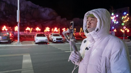 在吉林市阿什哈達(dá)霧凇觀景帶，霧凇播報(bào)員正在直播。新華社記者 李典 攝