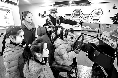 山東省榮成市公安局道路交通安全宣傳教育基地，交警帶領(lǐng)小學(xué)生現(xiàn)場(chǎng)體驗(yàn)?zāi)M駕駛。新華社發(fā)