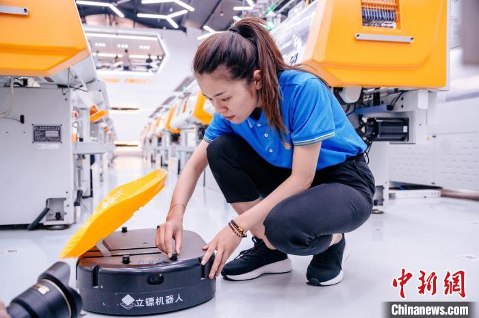 圖為員工在調(diào)試AGV搬運(yùn)機(jī)器人?！±钅宪?攝