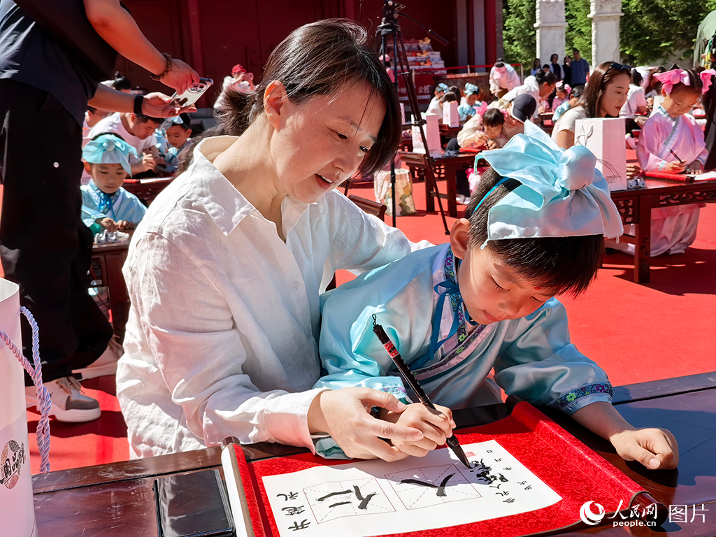 2026年5月30日，在吉林長春文廟博物館傳統(tǒng)啟蒙禮活動現(xiàn)場，孩子們提筆書寫“仁”與“人”，在古韻雅樂中篤學明禮，開啟嶄新的成長篇章。人民網(wǎng)記者 王帝元攝