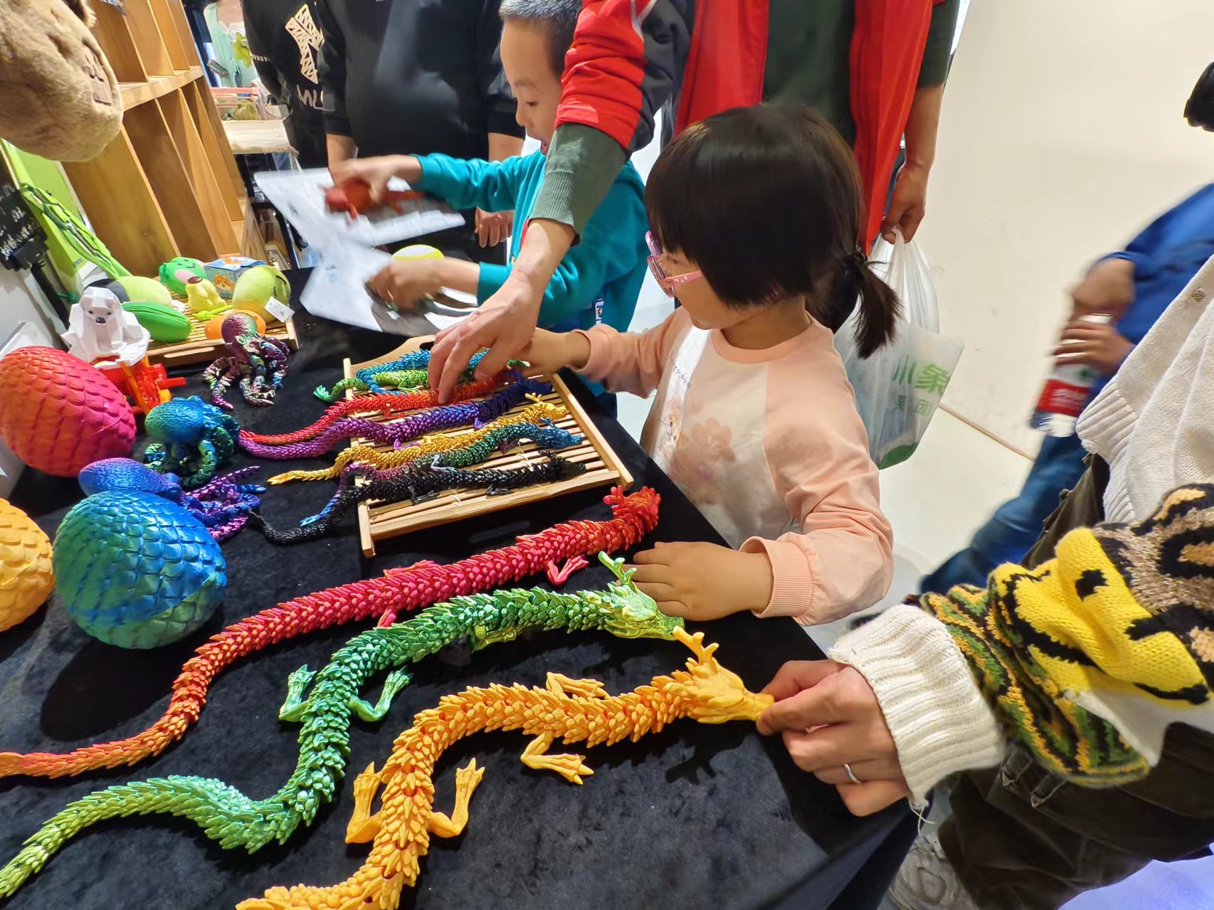在北京798某創(chuàng)意產品店內，孩子們正在選購3D打印的龍形玩具。人民網記者 喬業(yè)瓊攝